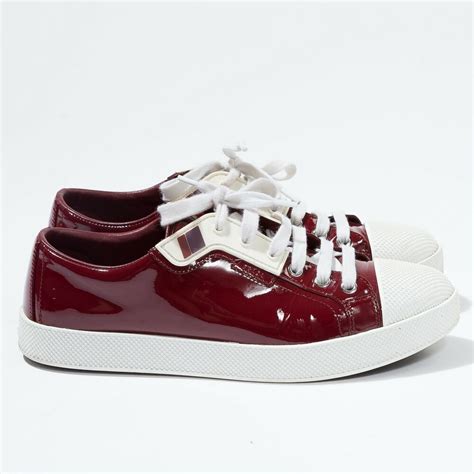 Prada burgundy patent leather sneakers .